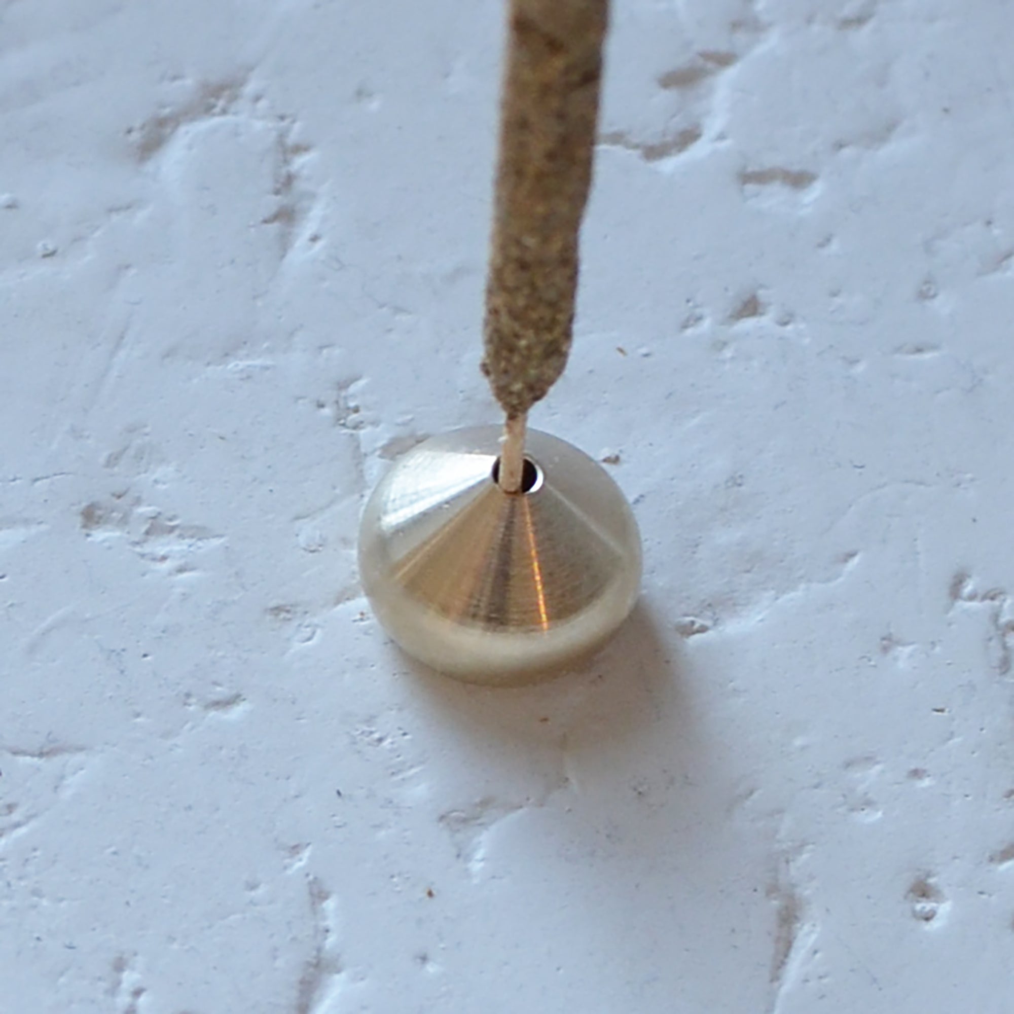 an incense stick with a medium waterdrop incense holder made of brass