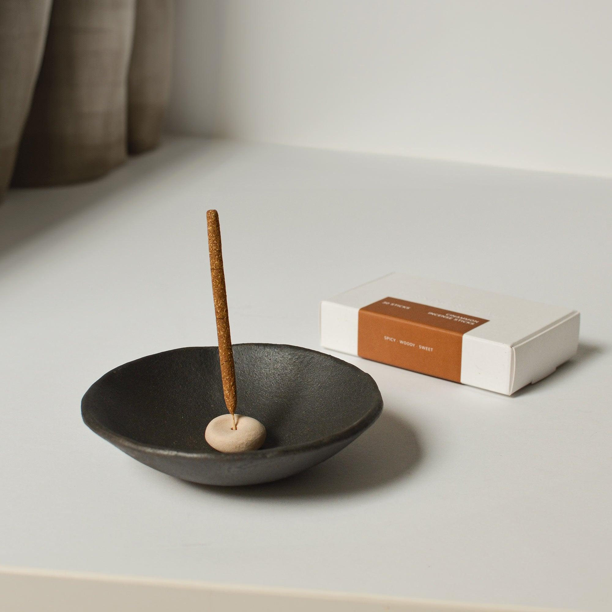 Left: mini cinnamon incense with mini pebble incense holder inside the smudge bowl; Right: package of mini cinnamon incense.