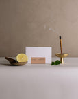 Left: Package of mini incense stick and lemon, wood, mint and ceramic plate; Right: Burning mini incense stick with ash catcher.