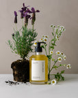organic aromatherapy body wash in glass pump botle displayed with fresh lavender and chamomile botanicals.