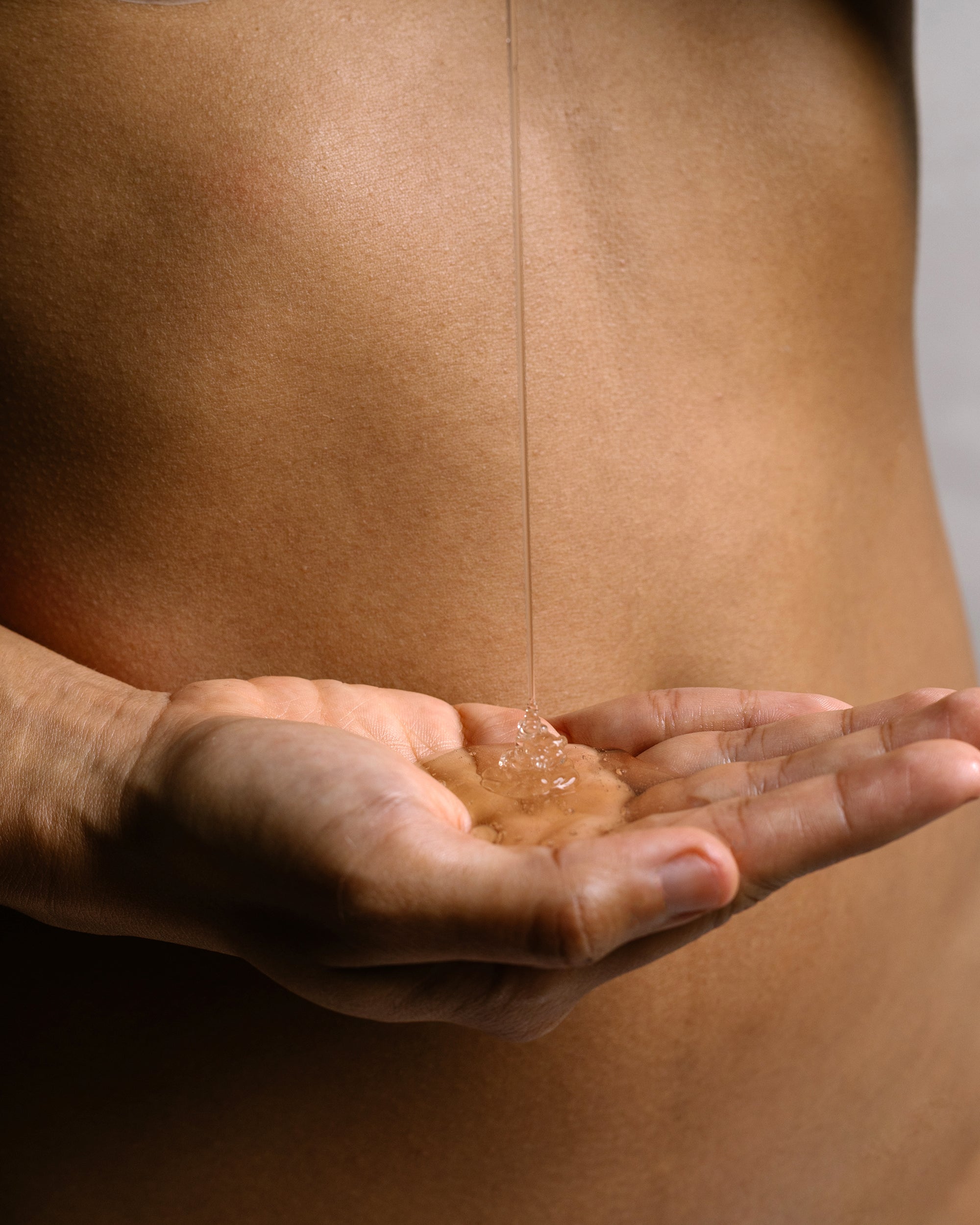 Organic body wash gel poured into hand, showing clear texture and gentle cleansing formula.