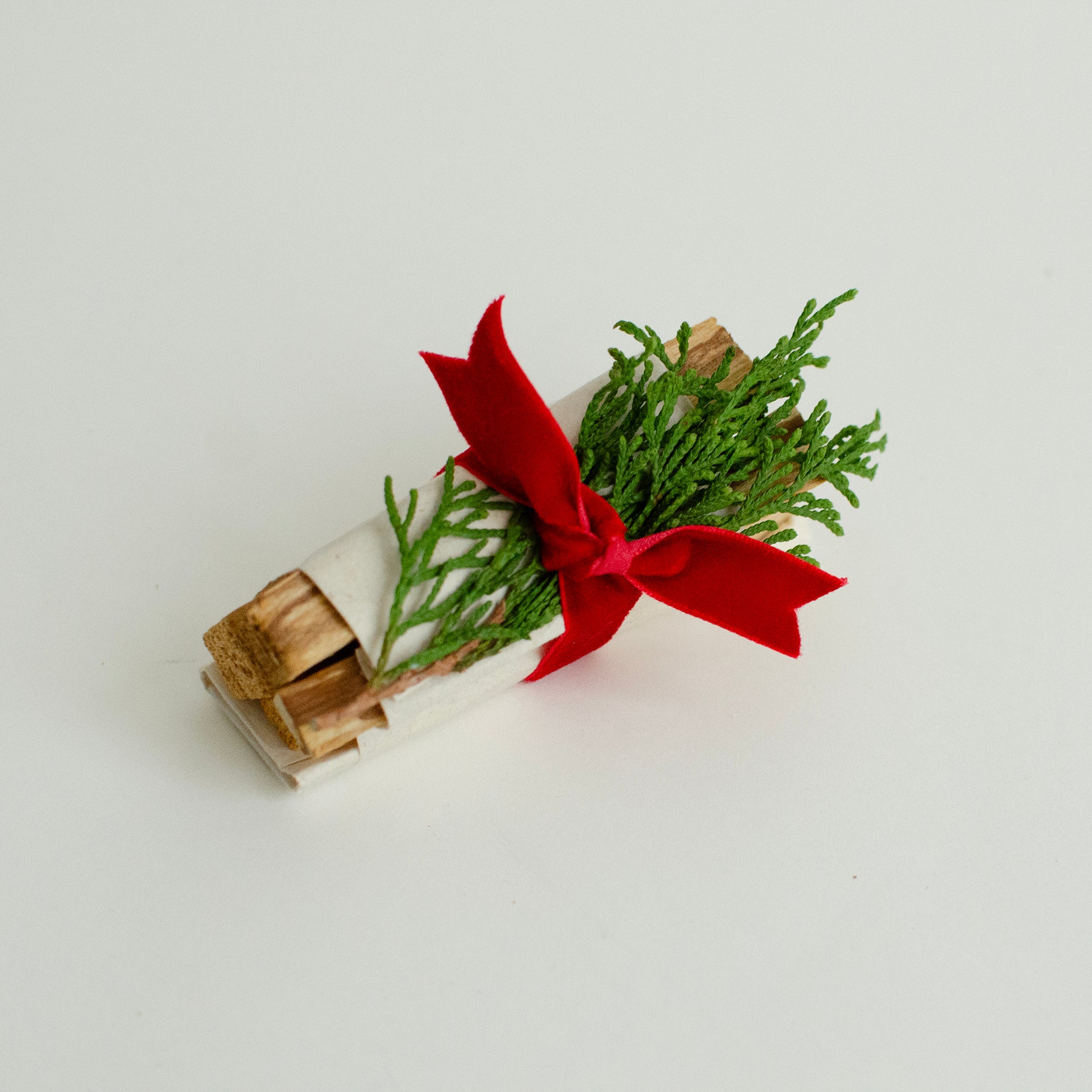 Hand-tied Palo Santo wood bundle with natural greenery and red velvet ribbon — Cedar & Myrrh Warm Welcome Gift Set