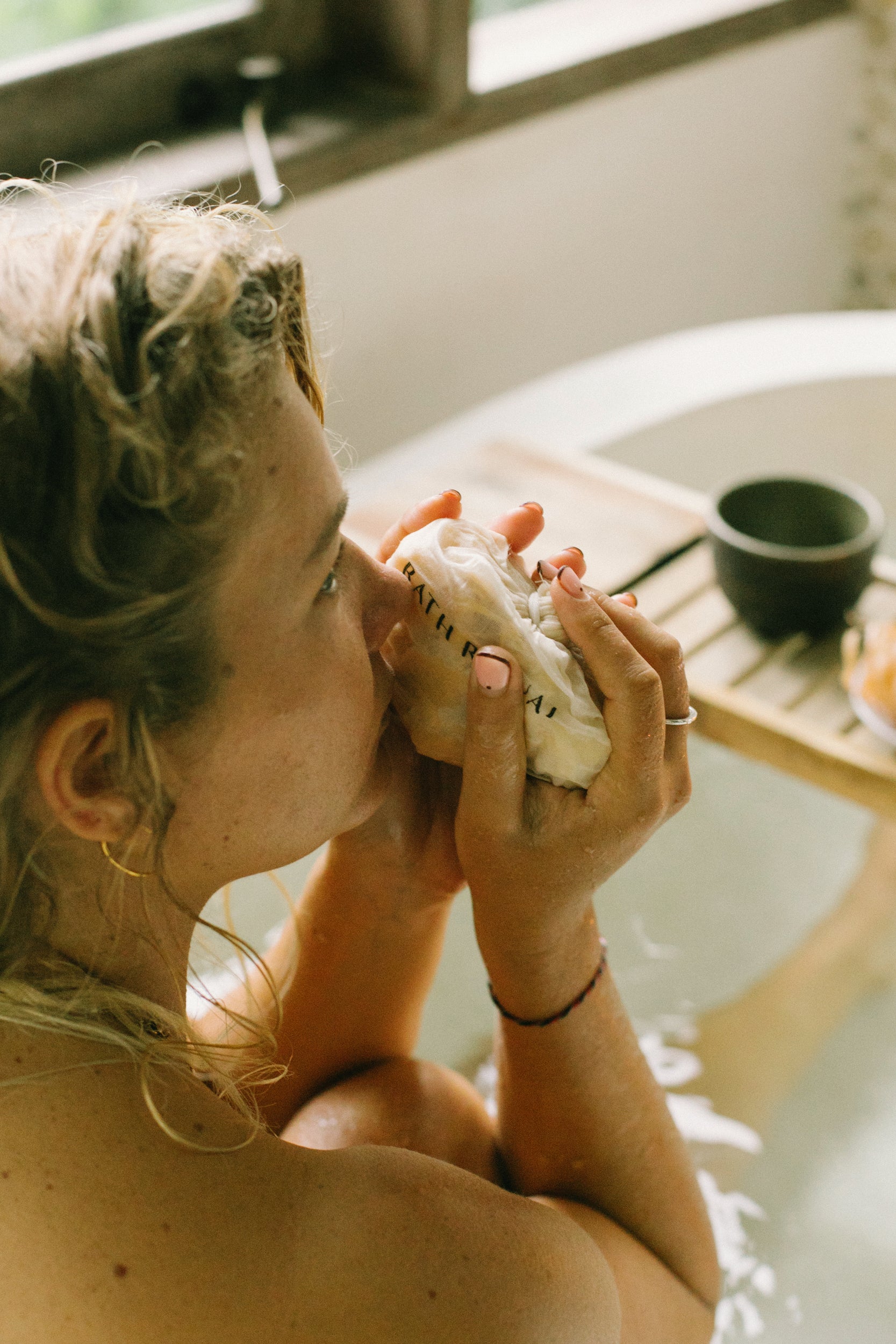 Woman enjoying an authentic Palo Santo wood bath ritual with Cedar and Myrrh, relaxing with natural cleansing aroma