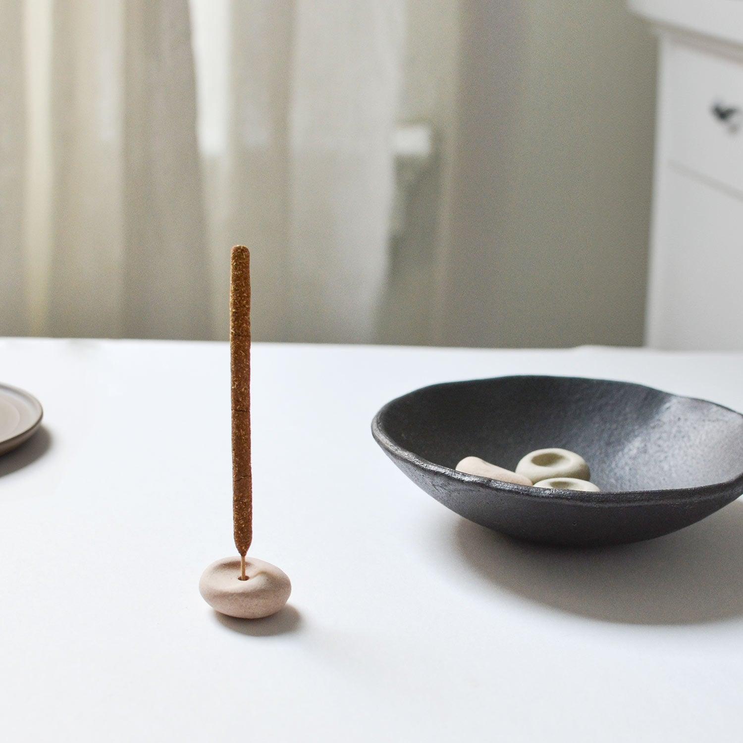 left: mini incense stick with mini incense holder beige pebble, Right: 3 pebble-shaped incense holders on the incense bowl