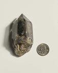 slanted phantom quartz with quarter coin