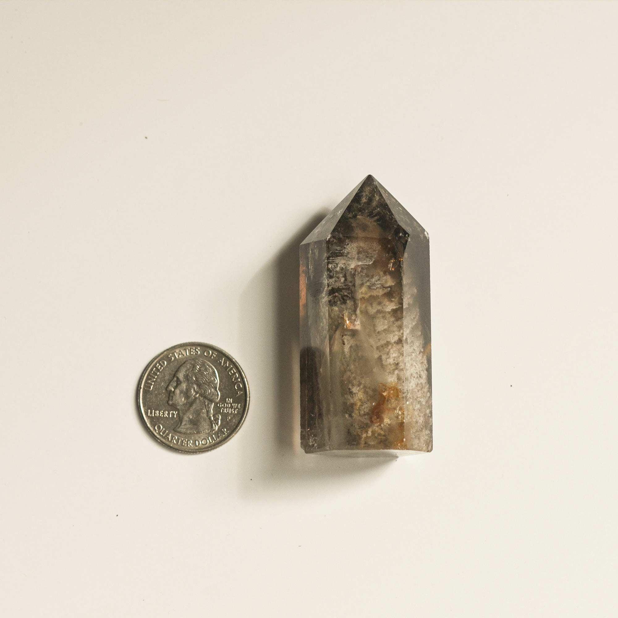 quarter dollar coin and phantom quartz in large hematite