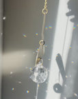 half moon shaped brass suncatcher with light reflections and rainbows