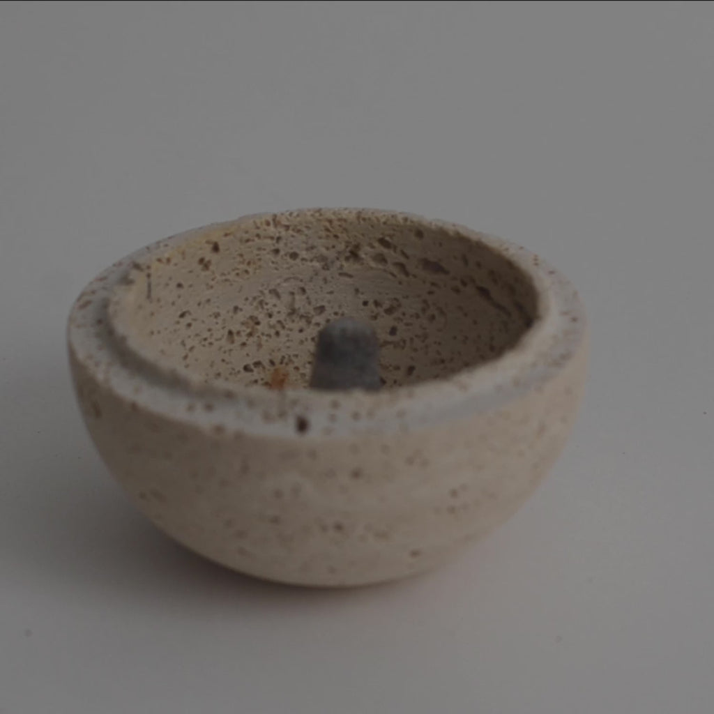 Smudging incense cone inside travertine sphere smudging burner