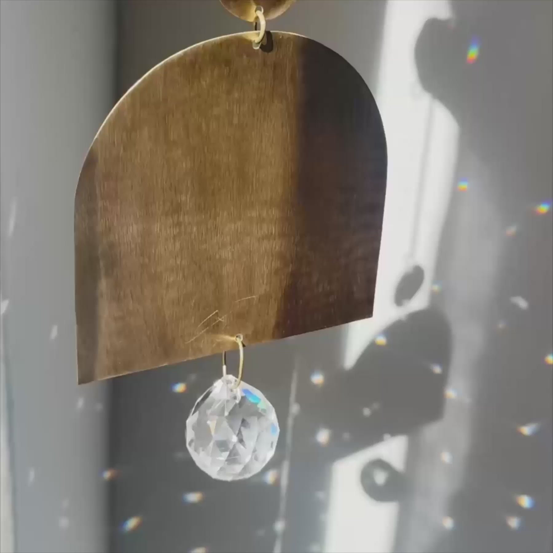 arch shaped brass suncatcher with light reflections and rainbows