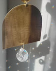 arch shaped brass suncatcher with light reflections and rainbows