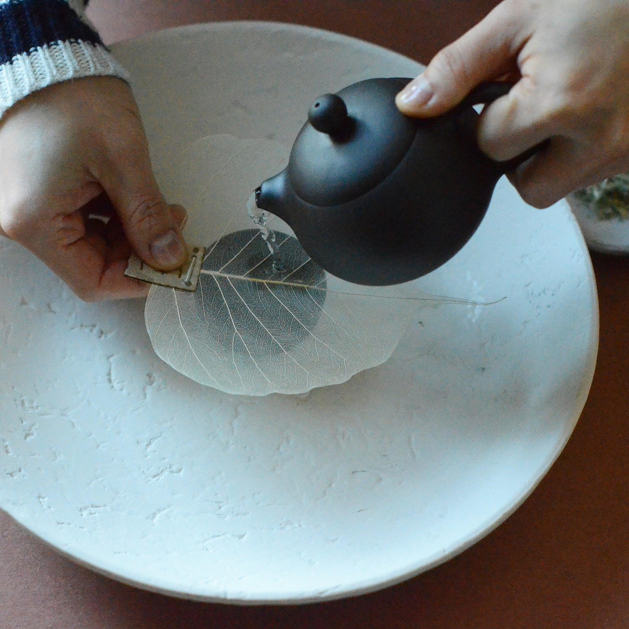 Pouring tea using a tea strainer