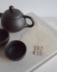 tea strainer with a tea cups and tea kettle