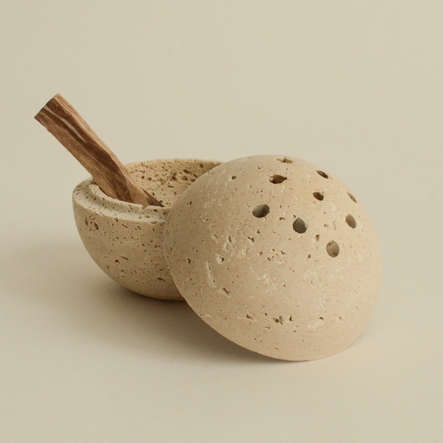 Stick of palo santo wood on traverine incense burner